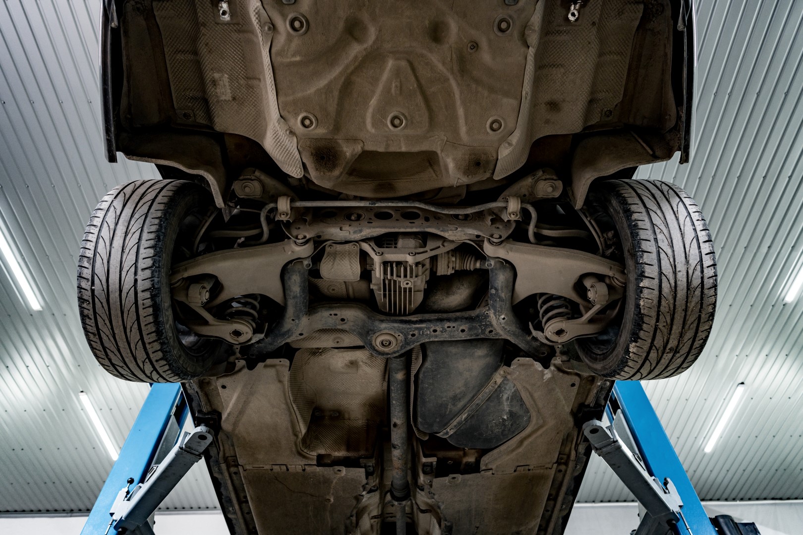 Сar in a car repair service lifted on a jack, view from the bottom