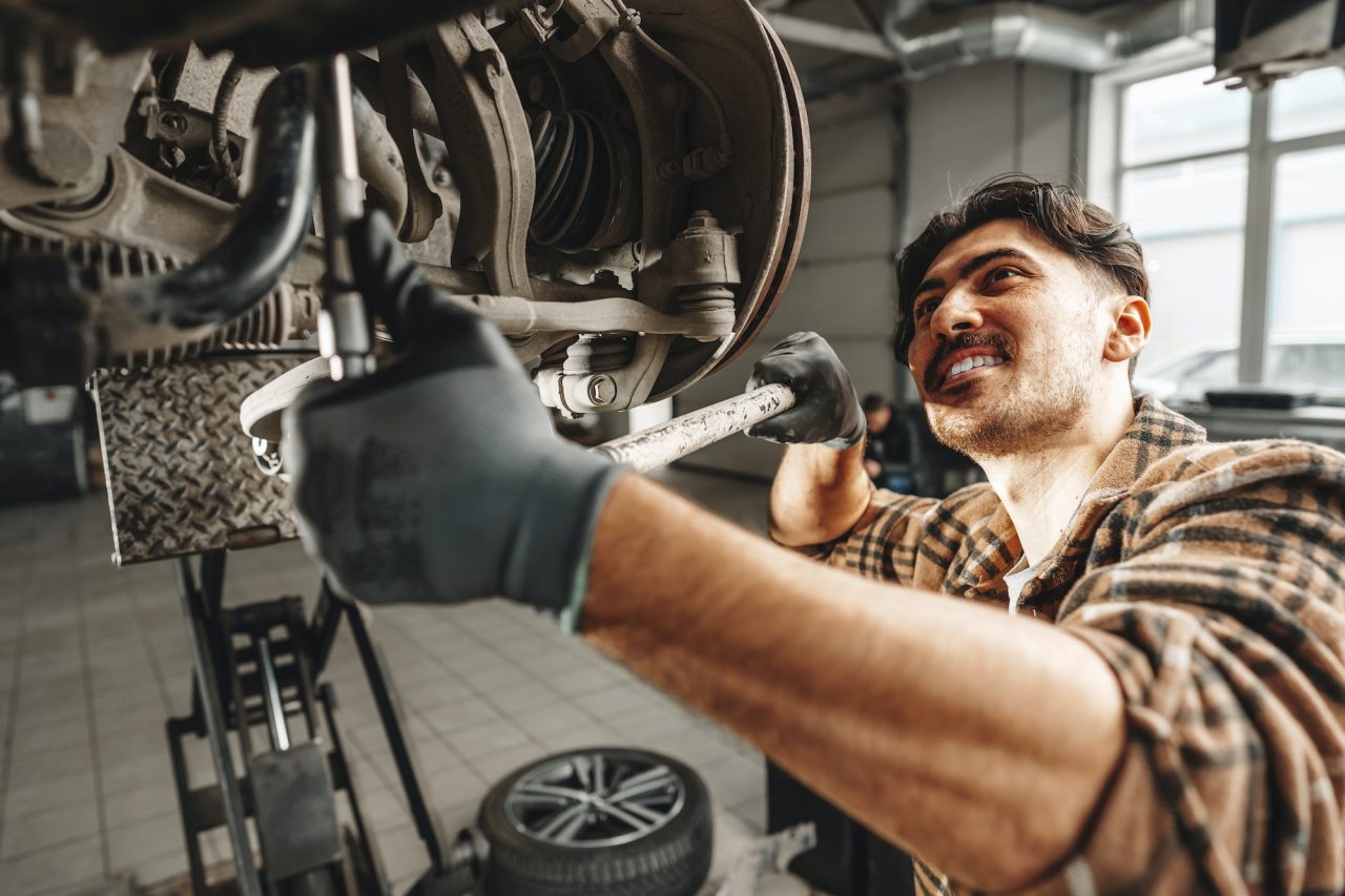 car mechanic working underneath a car