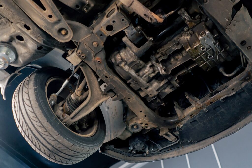 close-up at service station with a car under it that is raised on a lift bottom of the car