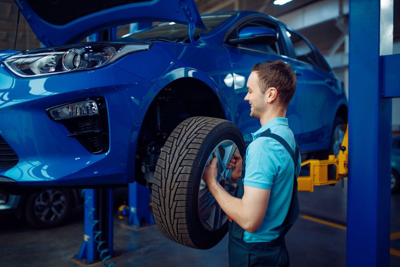 auto mechanic replacing a tire on a car