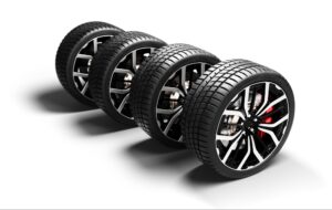 Four brand new performance car tires against a white background.